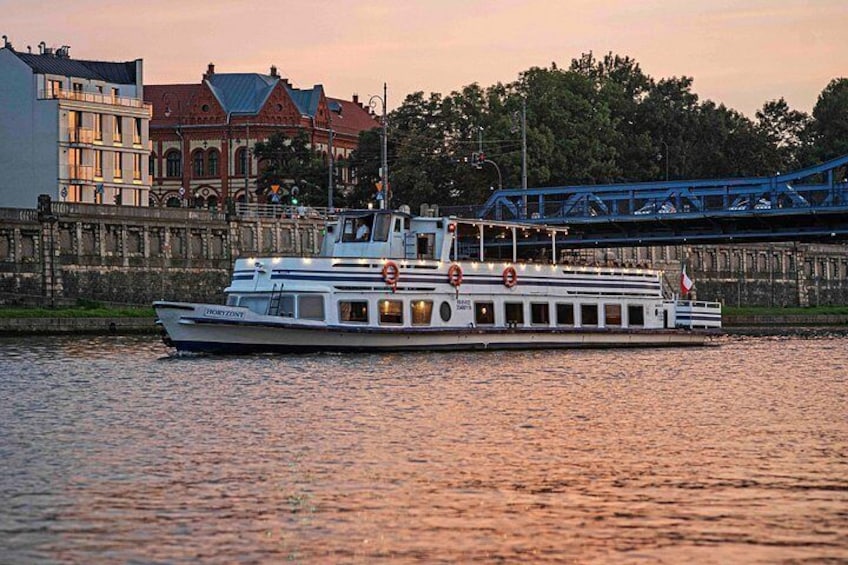 A white riverboat with lifebuoys, a bridge, and buildings in the background. 3