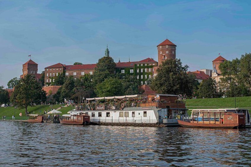 A river with boats, a castle, and a grassy area. 2