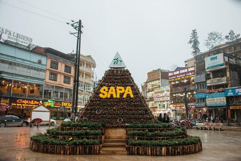 A Sapa pyramid with a sign, surrounded by shops and buildings. 4