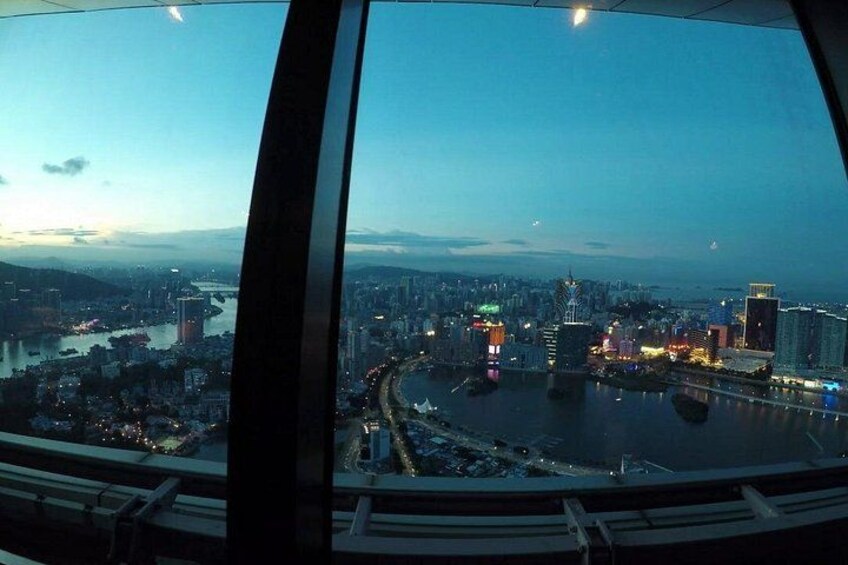 A cityscape at dusk with a river, bridges, and illuminated buildings. 3