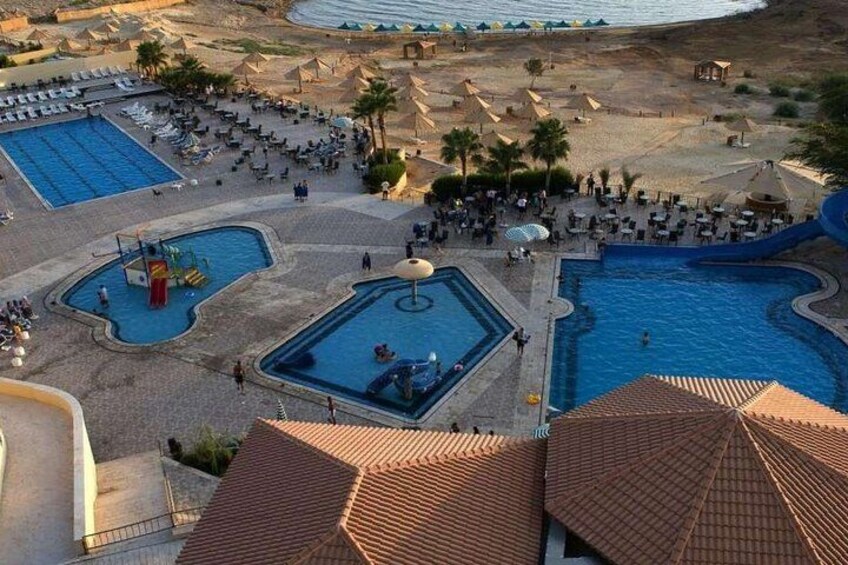 A resort with multiple swimming pools, sun loungers, and palm trees. 2