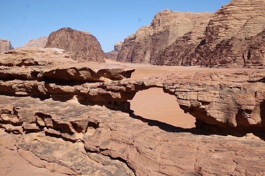 A desert landscape with prominent rock formations and a clear sky. 4