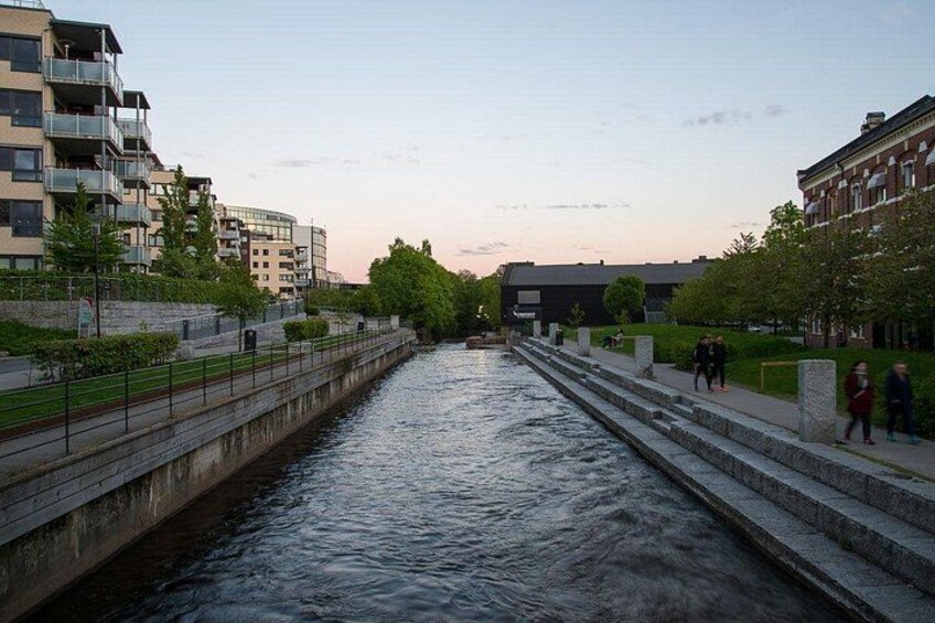 A canal with steps on both sides, surrounded by buildings and trees. 5