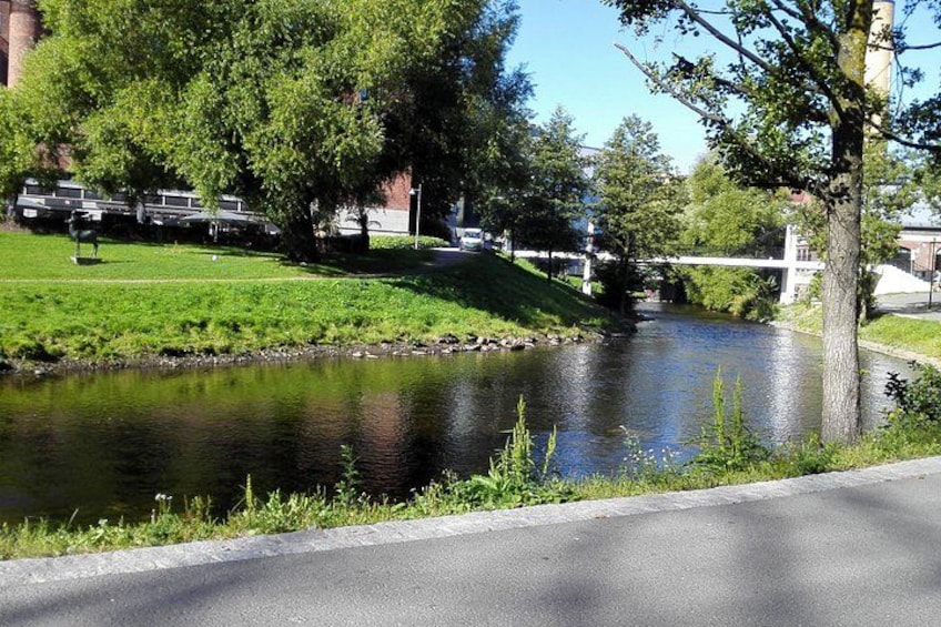 A river, grassy banks, trees, a bridge, and a road. 2