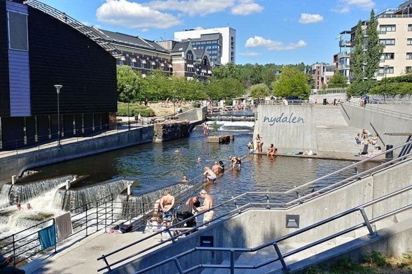 A water park with a waterfall, people swimming, and a building labeled 'hydalen'. 3