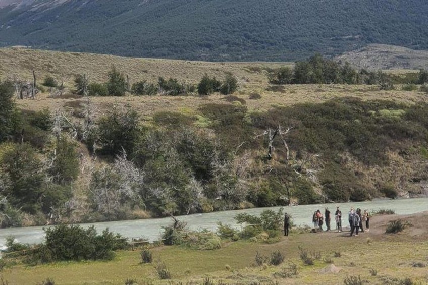 Une rivière, un groupe de personnes et un paysage vallonné. 5