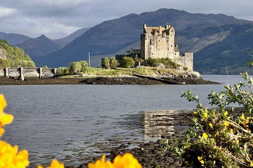Un château situé sur une petite île, entourée d’eau et de montagnes. 5