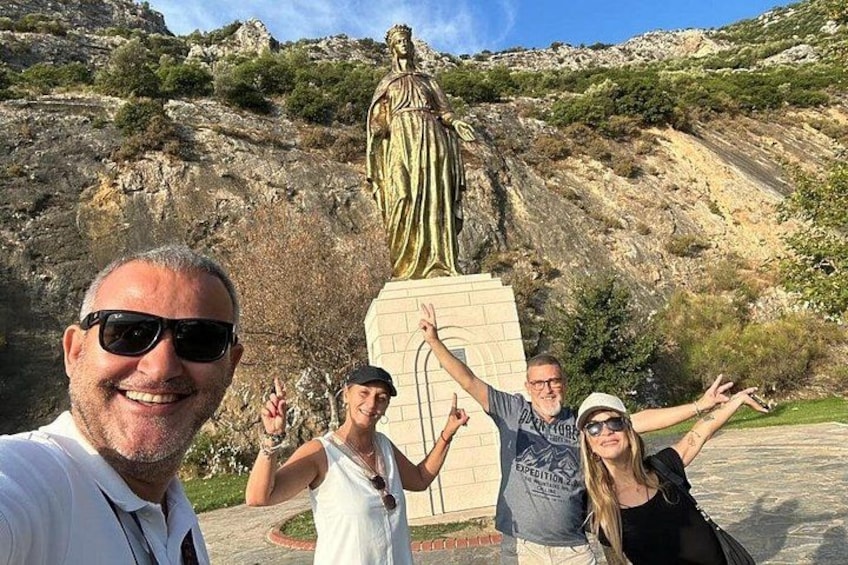 Un grupo de personas tomándose un selfie con una estatua al fondo. 1