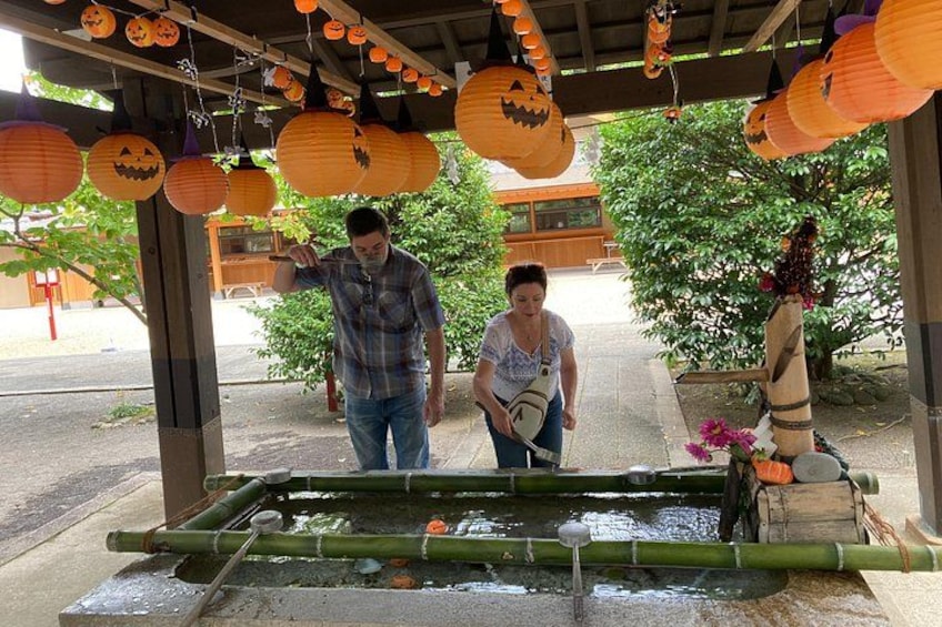 A covered outdoor area with a water feature, decorated with hanging lanterns and pumpkins. 2