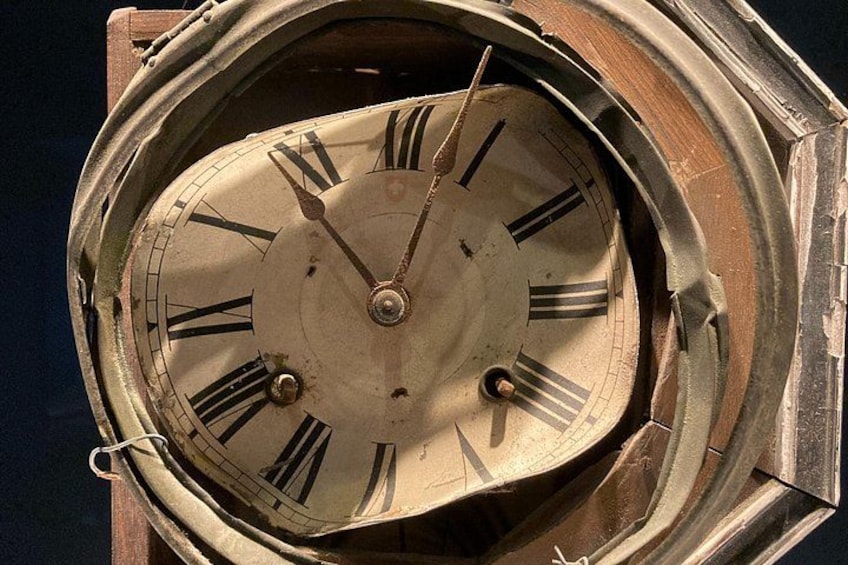 A close-up of an antique clock face with Roman numerals and a circular design. 4