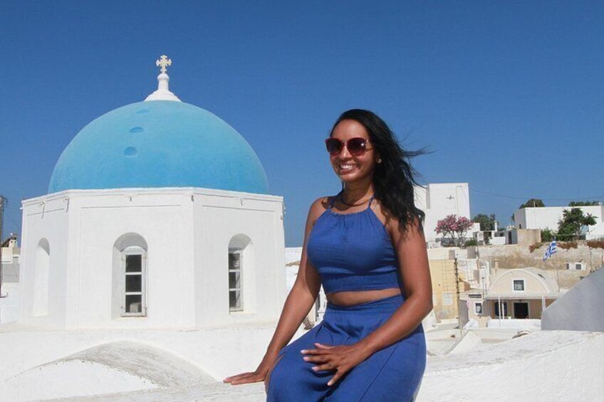 A person in a blue dress standing in front of a white building with a blue dome. 3