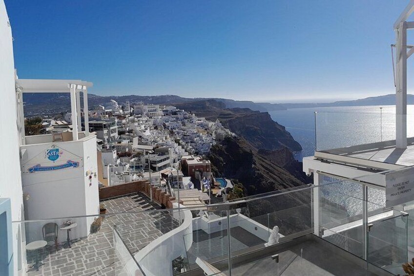A coastal town with a view of the sea, a staircase, and a building with a sign. 2
