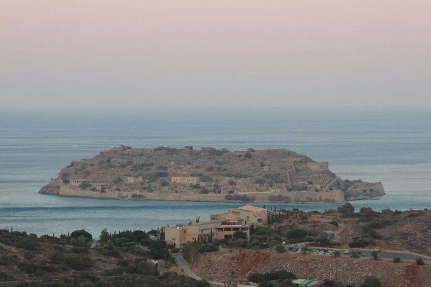 A coastal landscape with a small island, buildings, and a clear sky. 4