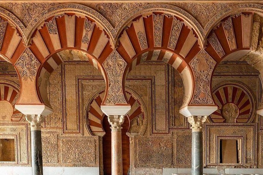 Une vue détaillée de l’intérieur d’un bâtiment historique, avec ses arches et ses colonnes richement décorées. 5