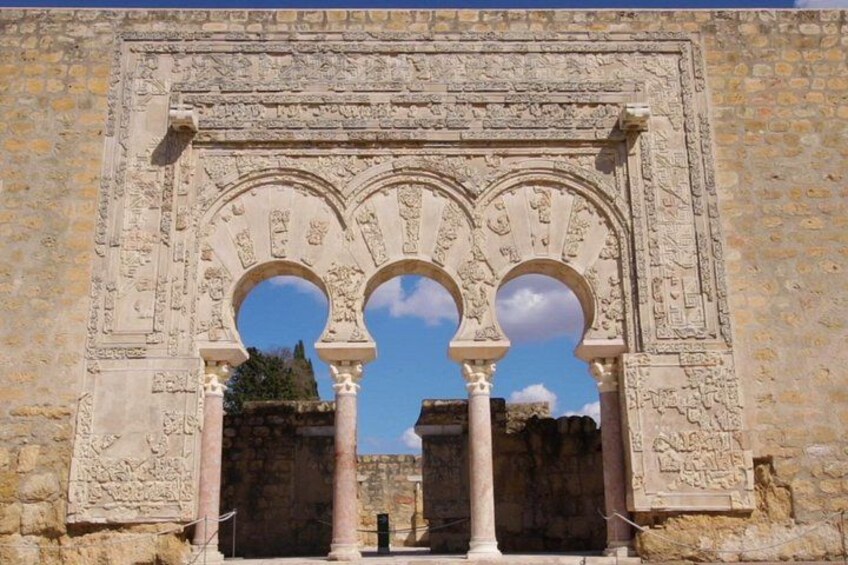 Un arc en pierre antique, orné de sculptures complexes et doté de trois ouvertures circulaires. 3