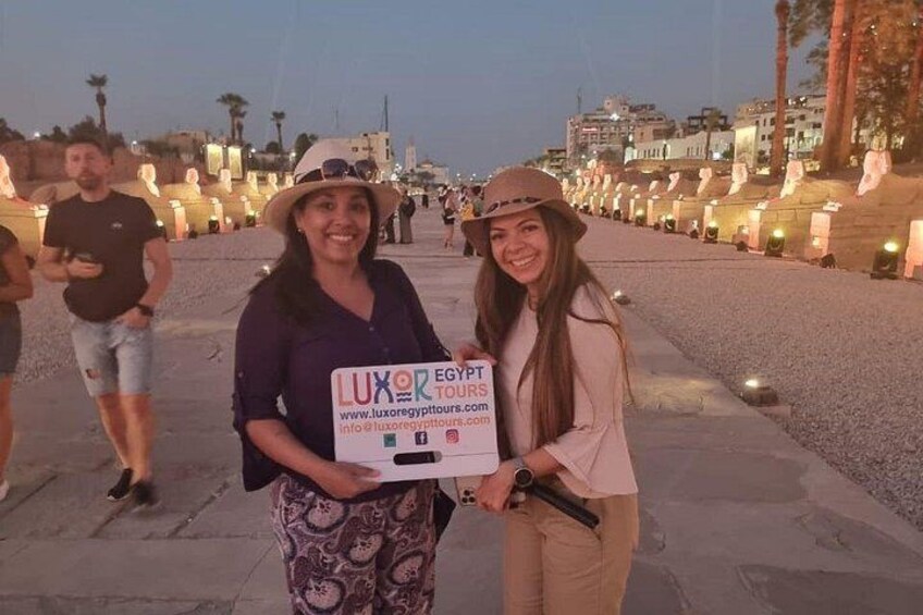 Två personer håller upp en skylt för researrangören Luxor Egypt Tours. 2