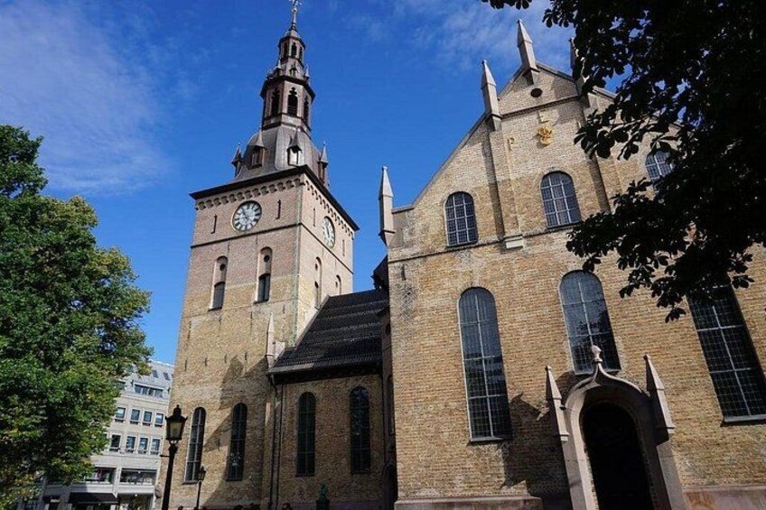 Una iglesia histórica con una imponente torre de reloj y ventanas de arco. 4