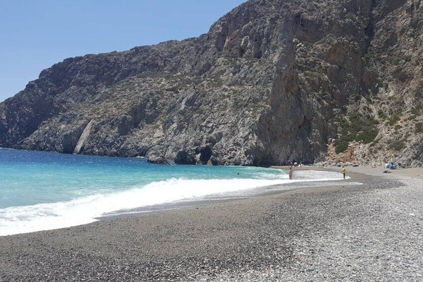 A rocky coastline with a pebbly beach and clear turquoise water. 4