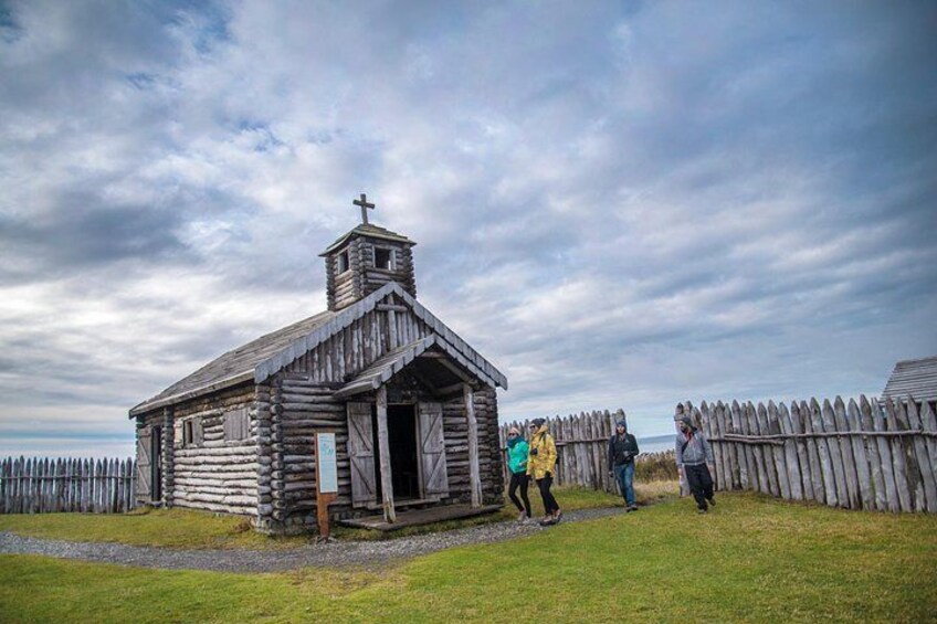 Une église en bois surmontée d’une croix, entourée d’une clôture en bois. 4