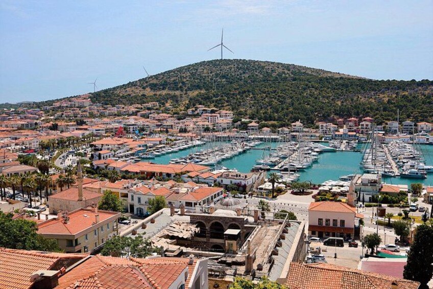 A coastal town with a marina, wind turbines, and terracotta-roofed buildings. 2