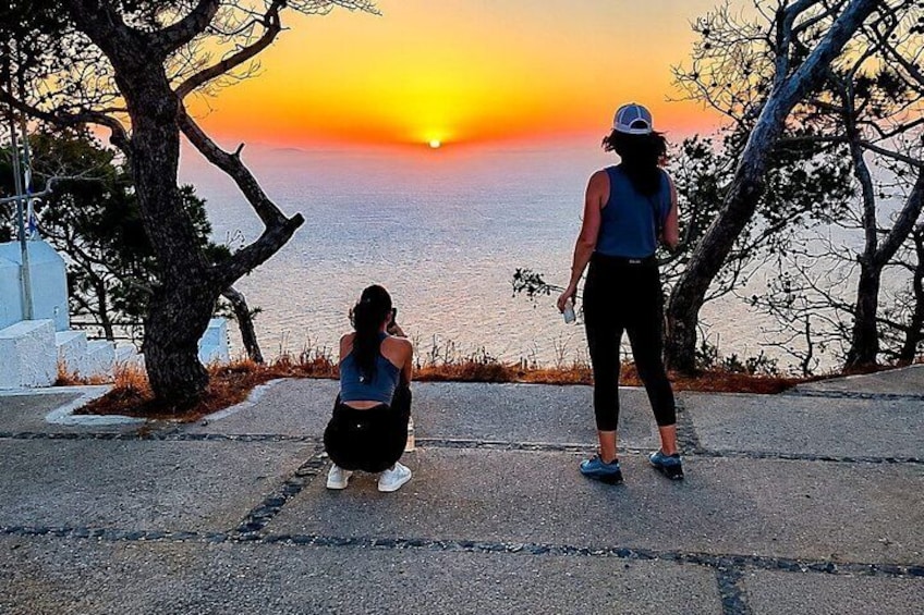 Deux personnes se tiennent au bord d’une route, d’où elles peuvent admirer le coucher de soleil sur la mer. 3