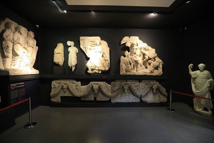 En museumsudstilling med gamle stensulpturer og relieffer. 2
