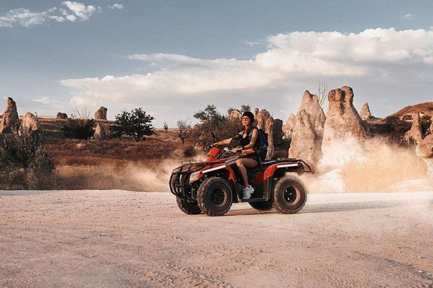 Un quad dans un paysage désertique, avec des formations rocheuses. 5