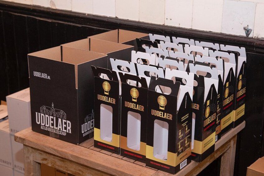 Cardboard boxes with UDDELAER beer packaging on a wooden pallet. 1