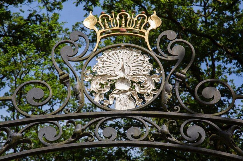 A wrought iron gate with a crest and a crown emblem. 2