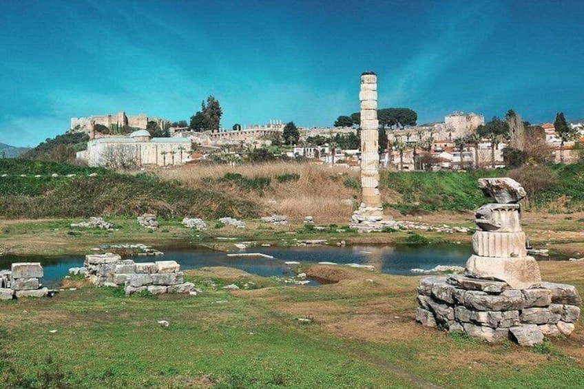 Ancient ruins, a tall column, and a small body of water. 3