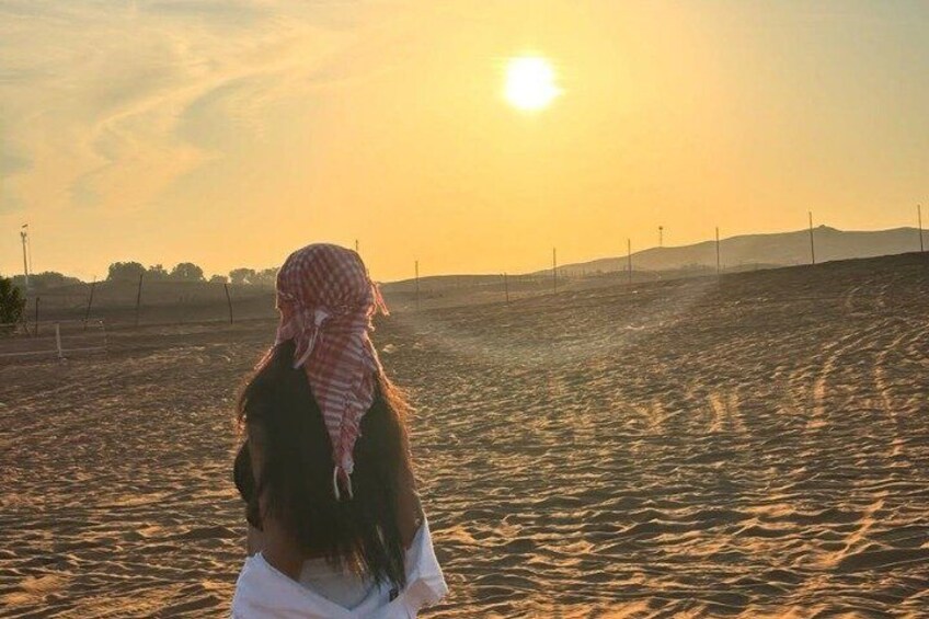 A person standing in a field with a sunset in the background. 3