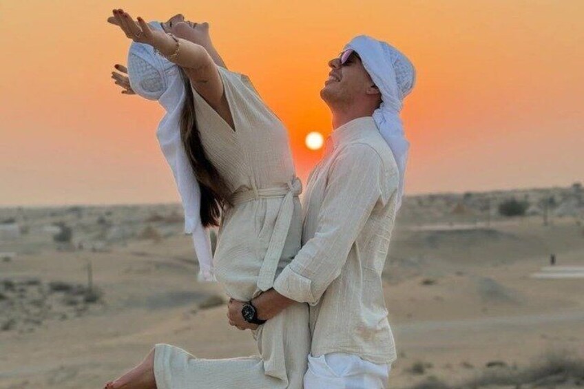 A couple embracing at sunset with a desert landscape in the background. 2