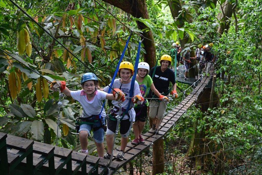 Personas cruzando un puente colgante en un bosque. 5