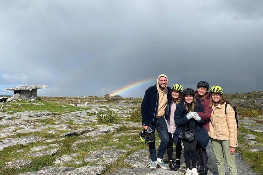 Une famille portant des casques, une structure en pierre et un arc-en-ciel. 3