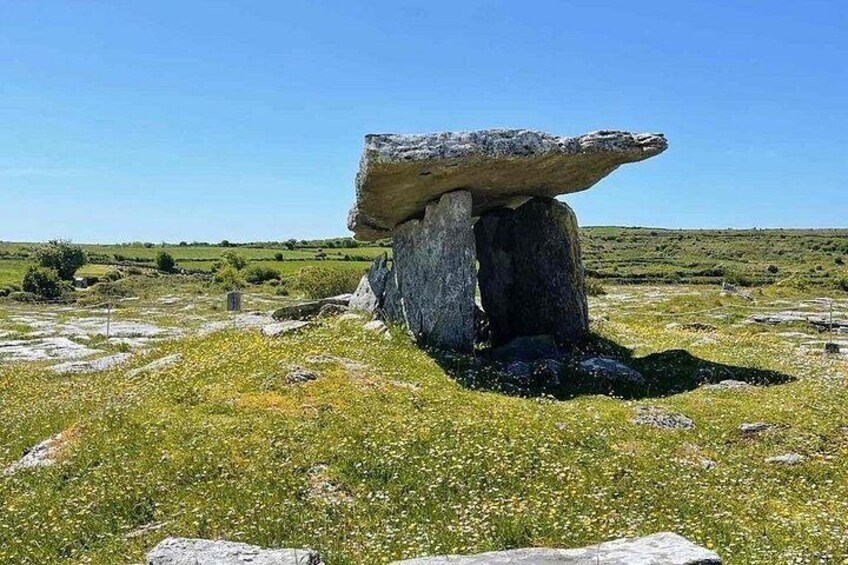 A standing stone in a grassy field with a clear sky. 5