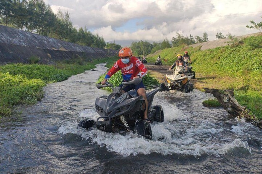 Une personne conduisant un quad à travers une rivière. 5