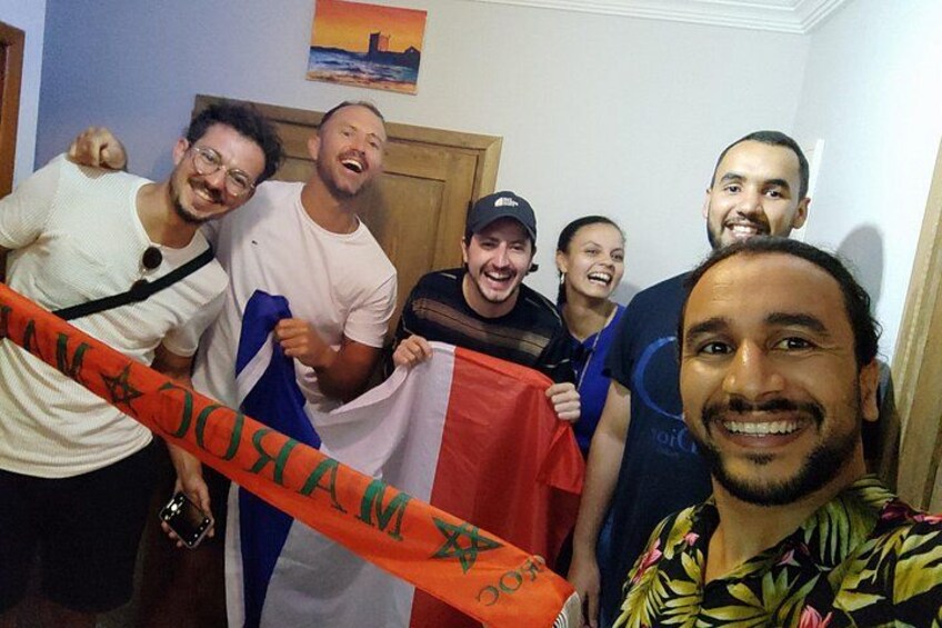 Un groupe de personnes tenant un drapeau orné d’une étoile et d’un croissant, se tenant à l’intérieur d’un bâtiment, avec une porte et un tableau en arrière-plan. 5