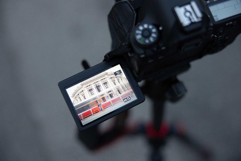 A camera with a viewfinder displaying a map and a red bus. 3