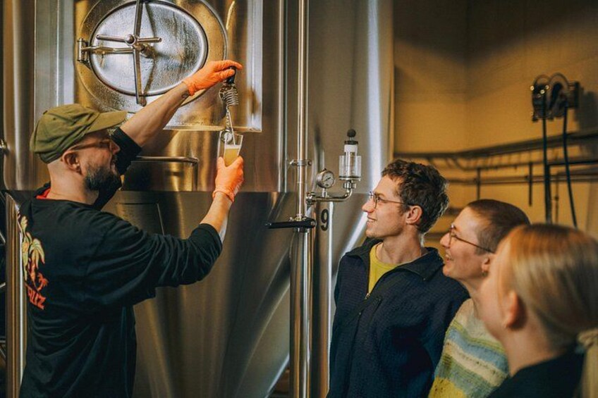 Una persona versa della birra da un rubinetto in un bicchiere. 1
