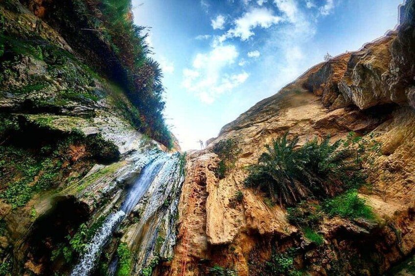 Un canyon étroit avec une cascade, un terrain rocheux et une végétation clairsemée. 1