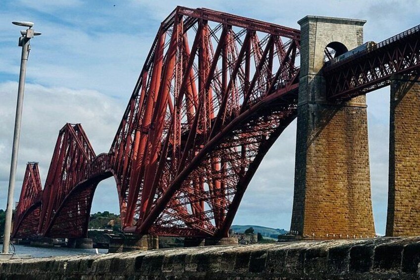 A red steel bridge with multiple arches over a body of water. 2