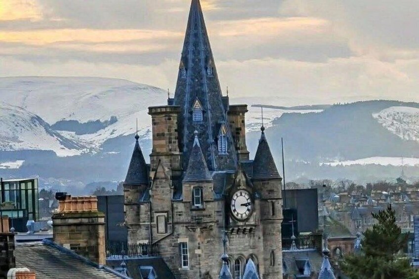 A historic church with a clock tower, surrounded by snow-covered hills. 3