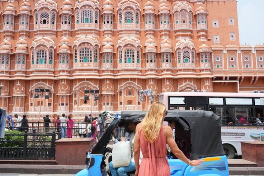 A large, ornate building with intricate architectural details and a group of people in the foreground. 2