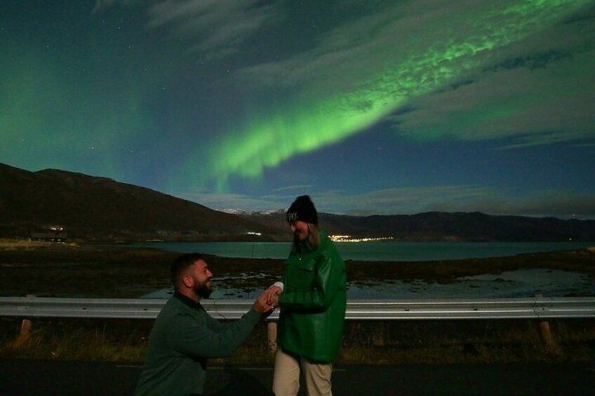 Zwei Personen stehen am Seeufer, während das Polarlicht am Himmel erscheint. 2