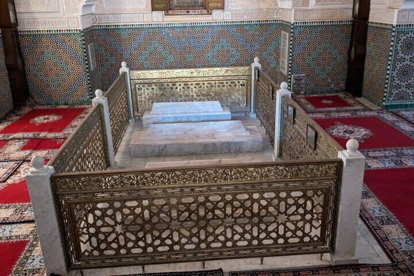 A staircase with ornate metal railings and patterned floor tiles. 4