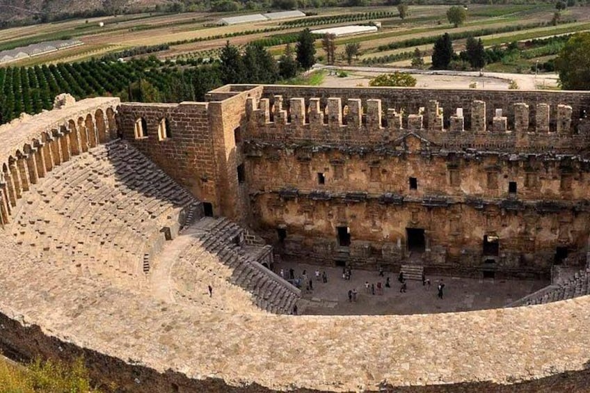 An ancient amphitheater with tiered seating and a central stage. 4
