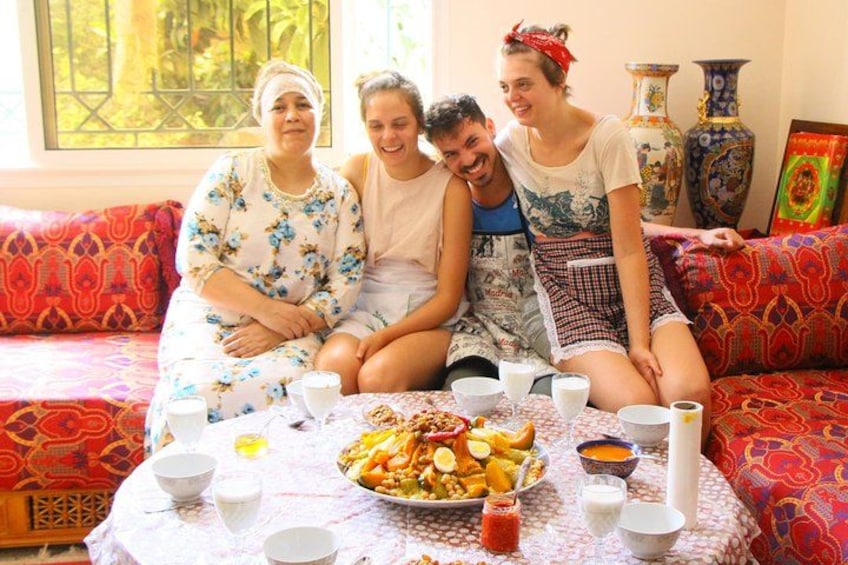 Cuatro personas sentadas en un sofá alrededor de una mesa con una bandeja de frutas y tazones. 1