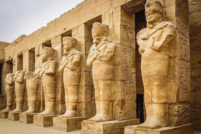 A row of ancient Egyptian statues in a temple. 3
