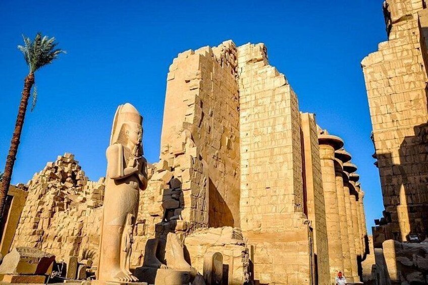 Ancient Egyptian ruins with large stone statues and columns. 5
