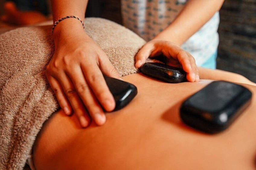 A person receiving a massage with a massage gun on their back. 2